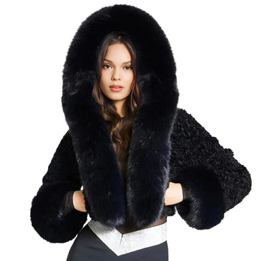 Black fur coat with hood worn by a model on a white background